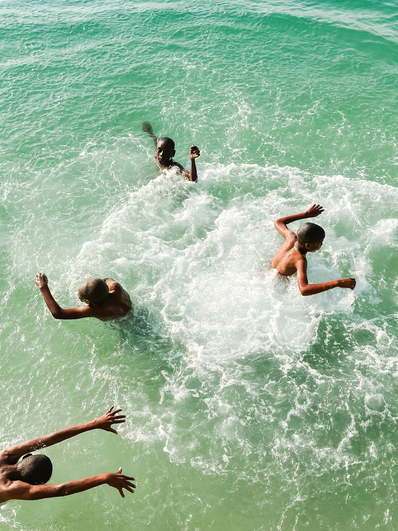 4 kids swimming in the ocean